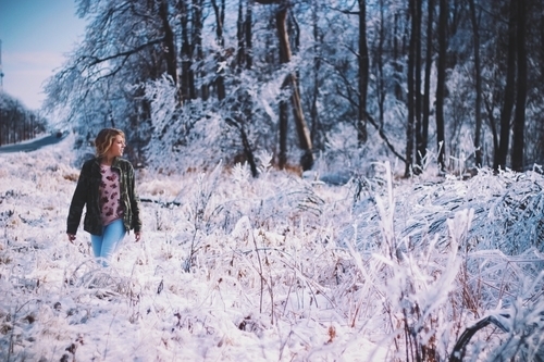 Girl walking through snowy forest