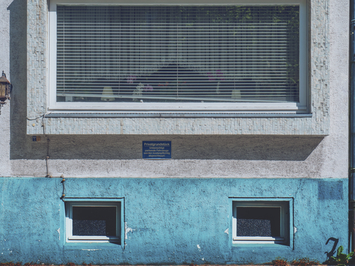 Fachada azul y ventana sombreada