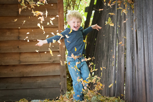 Boy running through leaves
