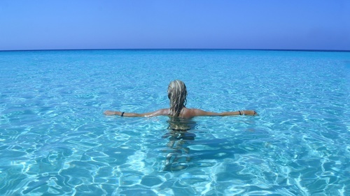 Tanned woman posing in the ocean