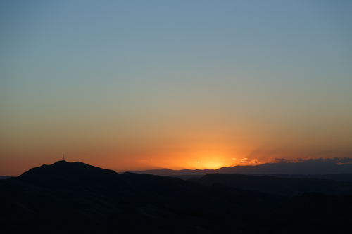 Під час заходу сонця промені через гори