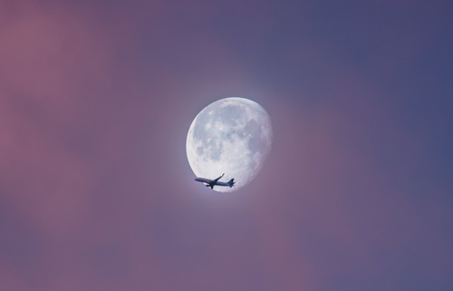 Airplane against the moon
