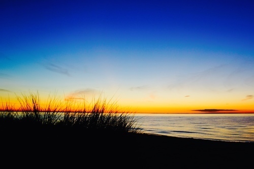 Solnedgång och silhuetten av stranden