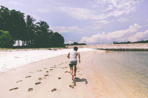 Homem correndo na praia