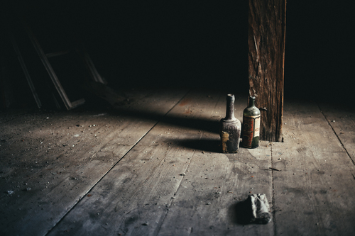 Bottiglie polverose in soffitta abbandonata