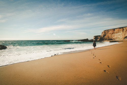 Donna che cammina sulla spiaggia