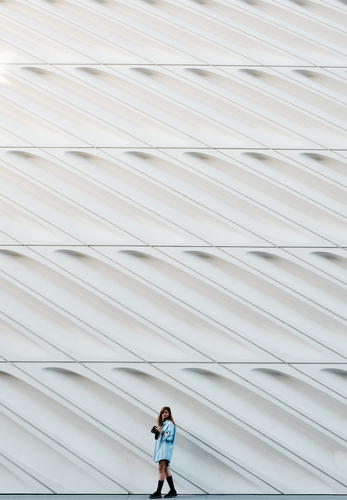 Flickan framför abstrakt vit vägg