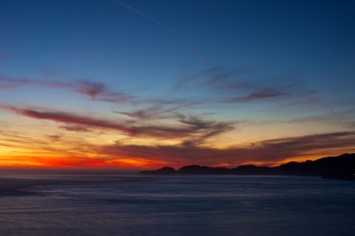 Sunset sky over ocean and shore