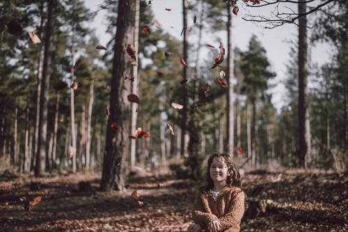 Девушка trowing листья в воздухе