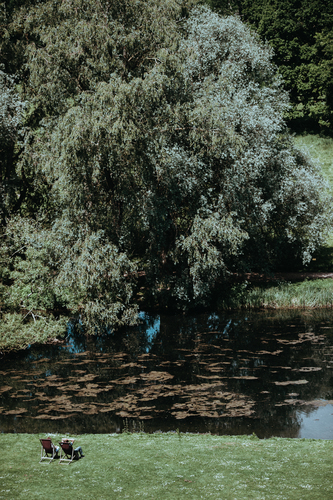 Couple sunbathing on a lake shore