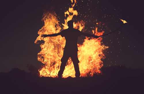 Muž stojící před plameny