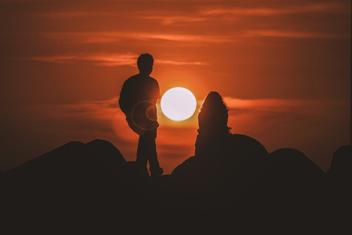 Hombre y mujer en puesta del sol