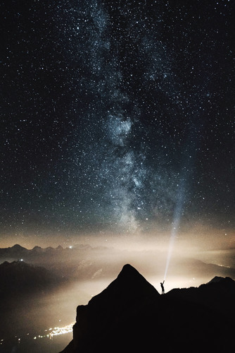 Ciel étoilé avec homme sur la montagne