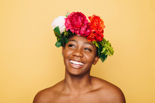 Усміхнена дівчина з квітами волосся