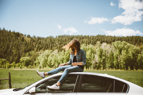 Girl at the top of the car in nature