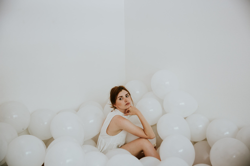 Chica sentada en globos