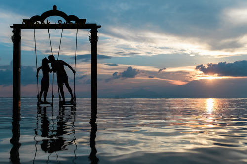 Man and woman swinging in the ocean