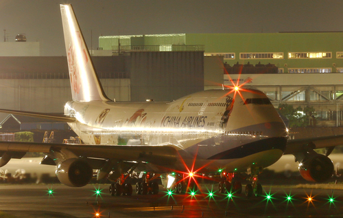 Avión estacionado en vista de noche del aeropuerto