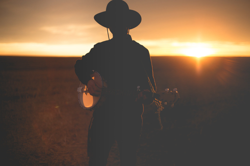 Banjo-speler in de zonsondergang