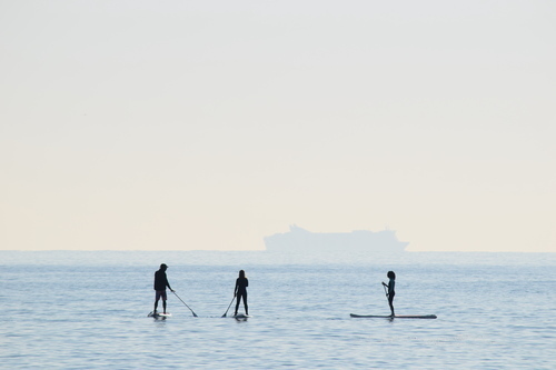 Drie surfers in water