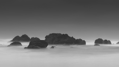 Mlhavo hladiny moře s útesy