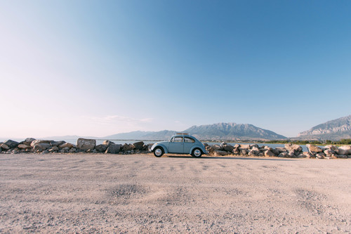 Blå Volkswagen Beetle på en sjö