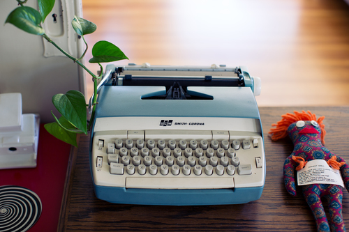 Blauwe schrijfmachine en pop
