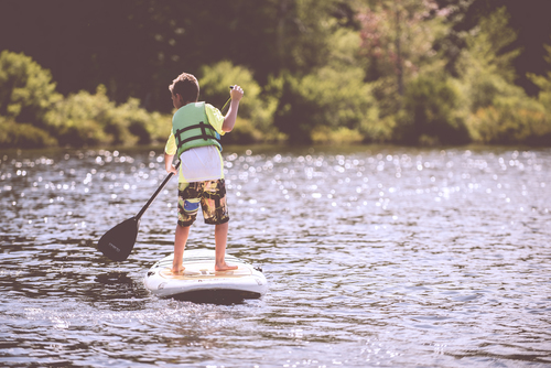 Хлопчик paddleboarding