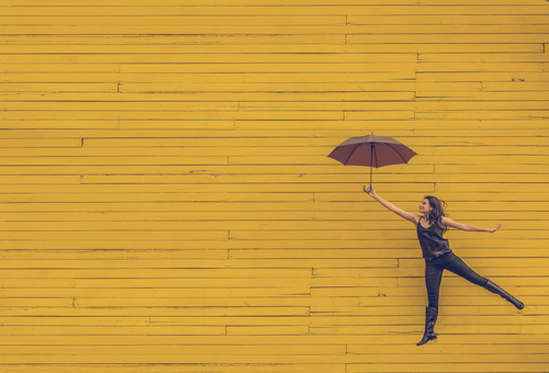 Gril in front of yellow wall