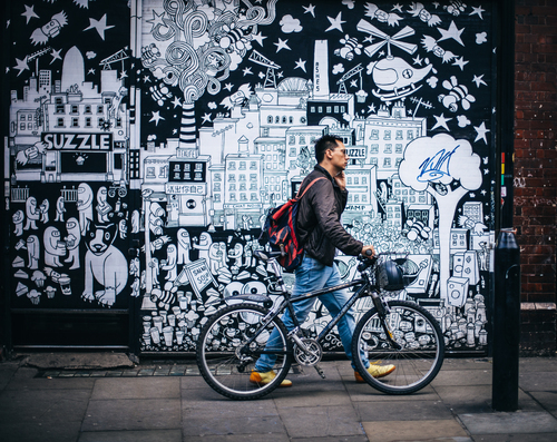 mn with bike in Brick Lane, London, UK