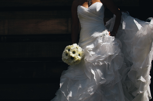 Bride stands with daisies