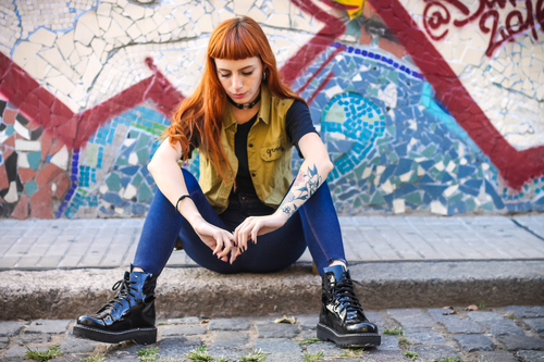 Punková dívka sedí na chodníku
