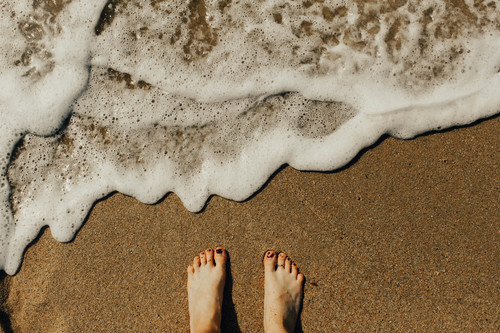 Pies en la arena de la playa