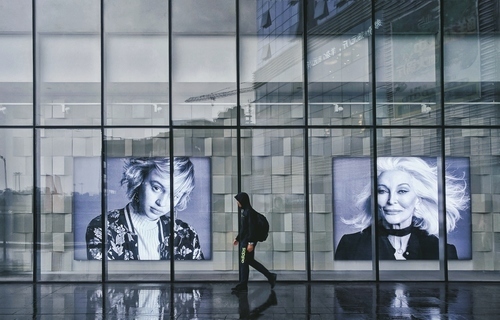 Pessoa na frente de retratos do Museu