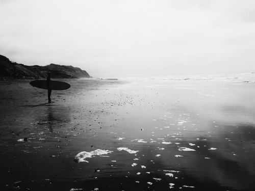 Серфер, стоячи на пляжі