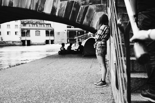 Girl by the canal and people under bridge