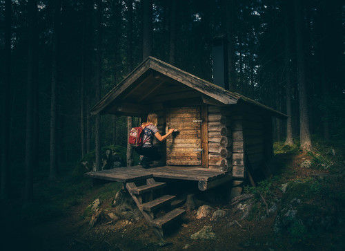 Woman in front of cabin in the woods