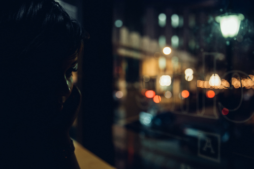 Verdrietig meisje in een café in de avond