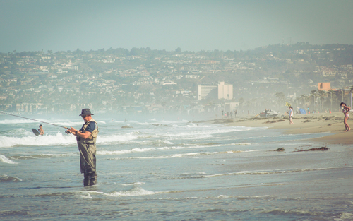 Hombre de pesca en la playa de California