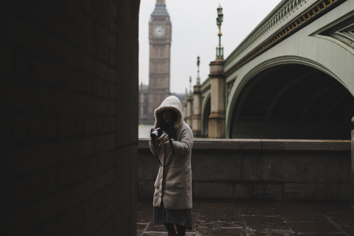 Coated girl with camera in London