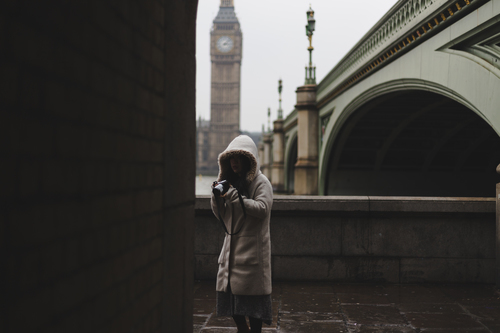 Gecoate meisje met camera in Londen