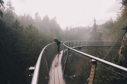 Человек на мосту в лесу