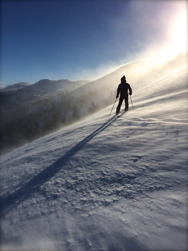 Hombre en la ladera nevada de la montaña