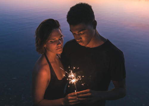 Pareja sosteniendo fuegos artificiales