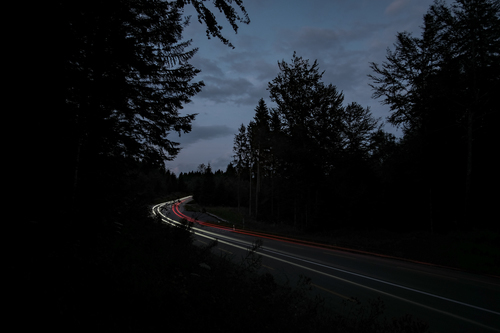 Carretera en la oscuridad con algunas luces de coche