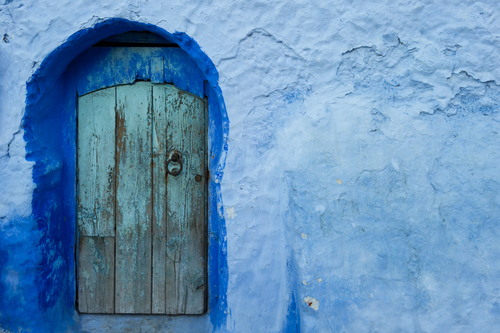 Parede azul com porta de madeira