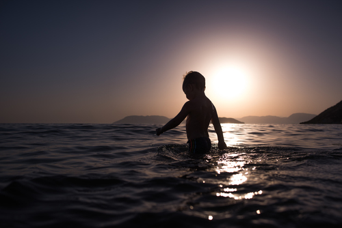 Niño entrando en el océano