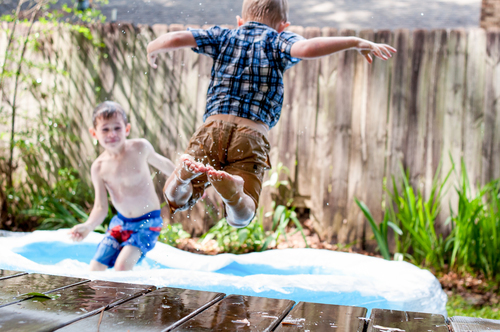 Children swimming in backyard