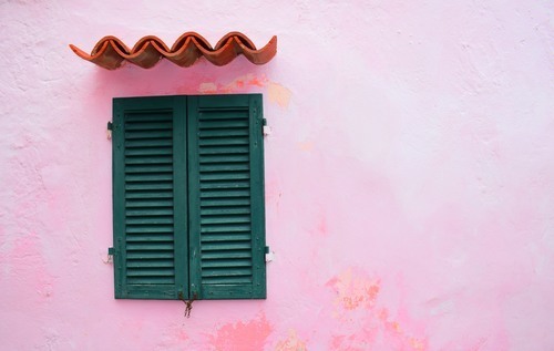 Ventana verde y pared rosa