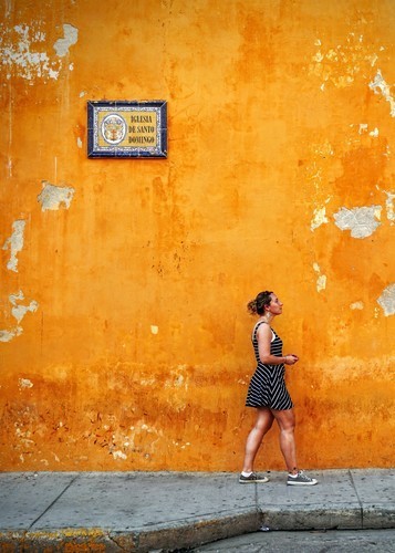 Senhora na frente da parede amarela